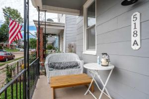 a porch with a table and a chair on a balcony at Historic Ludlow Suites - 2 Apts in Ludlow