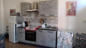 Una cocina con estufa, fregadero y refrigerador. en Casa Edo, en Castelsardo 2 fotos más