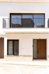 a white house with two doors and a balcony at Casa Rural con piscina privada en casco urbano de Náquera Botigueta 25 in Náquera +97 photos