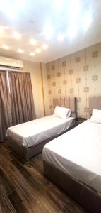 two beds in a hotel room with white sheets at aladdin hotel Egypt Badr in Cairo