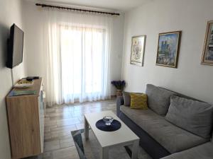 a living room with a couch and a table at Apartments Tessa 77 in Medulin