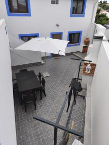 a patio with a table and an umbrella at Casa da Praça - Country Residence in Amoreira