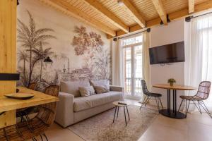 ein Wohnzimmer mit Sofa und Tisch in der Unterkunft Stay Unique Apartments Plaza del Marqués in Málaga