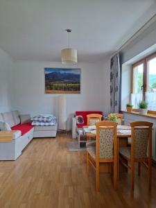 un salon avec une table, des chaises et un canapé dans l'établissement Janikowka apart 1 Droga na Szymaszkową 4, à Zakopane