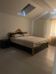 une chambre avec un lit avec un ventilateur de plafond dans l'établissement Vila cu 3 Dormitoare cu Acces la Lac, à Gheboieni