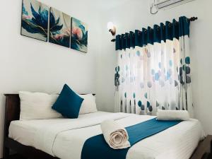 2 letti in una camera con blu e bianco di Heaven Breeze a Kandy
