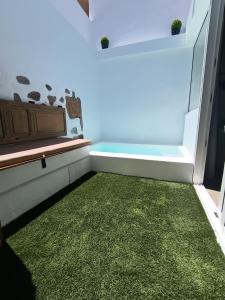 ein Zimmer mit einem grünen Teppich und einer Badewanne in der Unterkunft Tu rincón favorito, en Villa de Agüimes in Agüimes