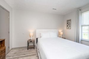 a white bedroom with a large bed and two lamps at Arkstone Retreat 2 - Chic 2 Bedroom in Williamstown +40 photos