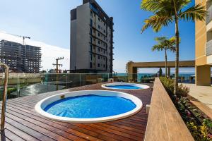 two hot tubs on the deck of a building at Venice Home Club - Balneário Piçarras in Itajubá