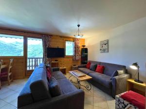 a living room with a couch and a tv at Les Menuires : Duplex 4 Pièces 8/10 pers, Wifi, Casier à Skis - FR-1-452-83 in Les Menuires