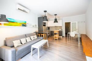 a living room with a couch and a kitchen at 11FOH1095 - Cosy apartment near Plaza España in Barcelona