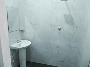 a white bathroom with a sink and a mirror at Janali Homestay in Kandy +35 photos