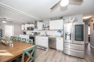 a kitchen with white cabinets and a wooden table with a dining room at Arkstone Retreat 3 in Williamstown