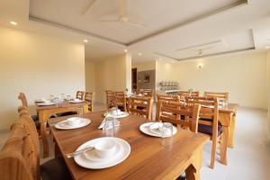 een eetkamer met houten tafels en stoelen bij Mahadev Villa Manali in Manāli