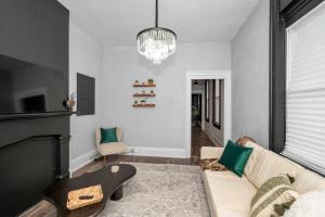 a living room with a couch and a chandelier at Stylish Modern Gem in the HIlls in Cincinnati +24 photos