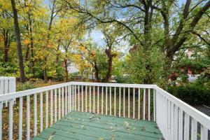 a wooden walkway with a white fence and trees at Stylish Modern Gem in the HIlls in Cincinnati