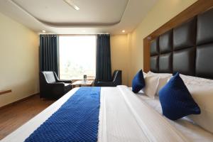 een hotelkamer met een groot bed met blauwe kussens bij Mahadev Villa Manali in Manāli