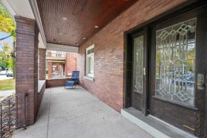 a brick building with a door and a chair on a sidewalk at Westside Wanderlust with Hot Tub in Cincinnati