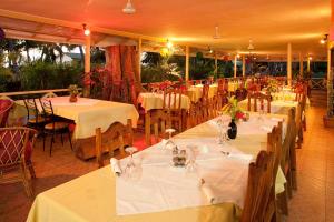 a restaurant with tables and chairs with white table cloth at Orchid Self Catering Apartment in La Digue