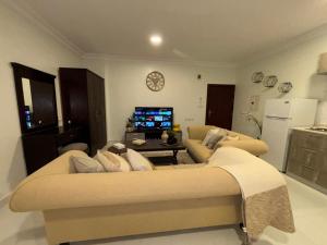 アル・コバールにあるشقة مودرن دخول ذاتيのリビングルーム(大きなソファ、テレビ付)