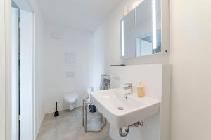 a white bathroom with a sink and a toilet at Bunker Loft Messe Essen Self Check-in in Essen