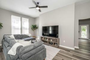 a living room with a couch and a flat screen tv at Queen City Grand House in Cincinnati +64 photos