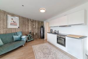 a living room with a green couch and a kitchen at Bunker Loft Messe Essen Self Check-in in Essen +8 photos