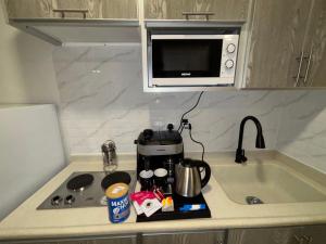 アル・コバールにあるشقة مودرن دخول ذاتيのコーヒーメーカーと電子レンジを備えたキッチンカウンター +4枚の写真