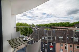 a room with a balcony with a table and chairs at Bunker Loft Messe Essen Self Check-in in Essen