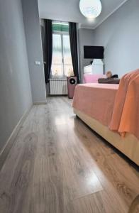 a bedroom with a bed and a wooden floor at Il giardino in città Savona in Savona