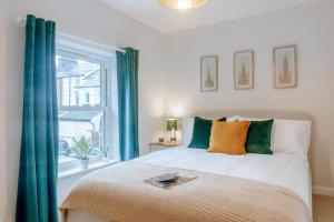 a bedroom with a bed with green curtains and a window at Mayfield Two - Central Harrogate Apartment in Harrogate