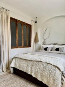 a white bedroom with a large bed and a window at VINEÀ Suite in Angé