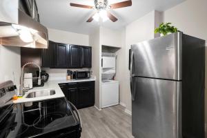 a kitchen with a stainless steel refrigerator and black cabinets at The Luxe Pearl Residences in Columbus