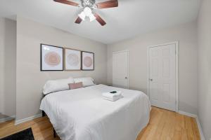 a bedroom with a white bed with a ceiling fan at The Luxe Pearl Residences in Columbus +19 photos
