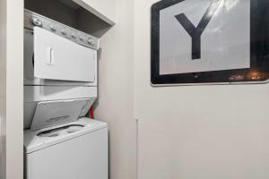 a kitchen with a washer and dryer next to a refrigerator at The Luxe Pearl Residences in Columbus