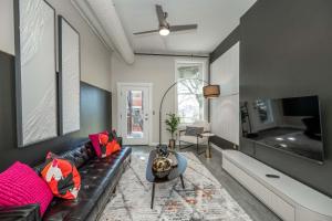a living room with a black leather couch and a tv at Queen City Views 2 Sleeps 2 in Cincinnati