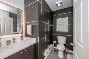 a bathroom with a sink and a toilet and a mirror at Queen City Views 2 Sleeps 2 in Cincinnati