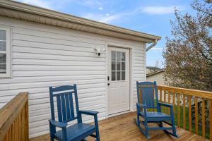 two blue chairs sitting on a deck with a house at The Restful Ark in Crittenden