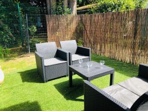 a patio with two chairs and a table on the grass at Studio in Boucau