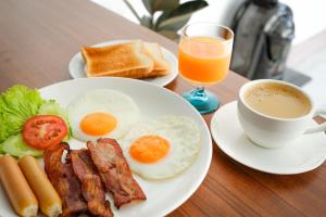 ein Teller mit Eiern, Speck und Toast sowie eine Tasse Kaffee in der Unterkunft Tropea Vicoli Storici Adesi in Tropea
