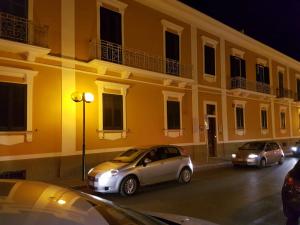 Nachts parkten zwei Autos vor einem Gebäude. in der Unterkunft Santa Marta in Matera