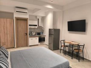 a kitchen with a refrigerator and a table and chairs at Down Town Skiathos in Skiathos