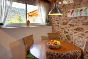 a dining room table with a bowl of fruit on it at Villa Es Coral in Cala Vadella