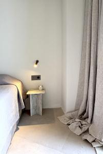 a bedroom with a bed and a table with a curtain at Nikiti Blue house 30m from the beach with sea view in Nikiti