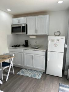 a kitchen with white cabinets and a white refrigerator at Un rinconcito en Miramar in Miramar