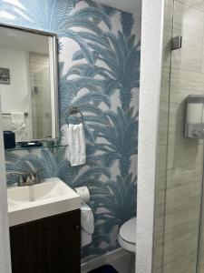 a bathroom with a sink and a toilet with a wallpaper at Un rinconcito en Miramar in Miramar
