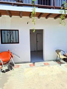 a room with two chairs and a table and a door at Borealis Apartahotel Tolú in Tolú +24 photos