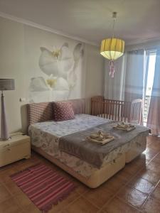 a bedroom with a bed and a painting of flowers at Apartamentos Arrifes 1 in Porto Santo