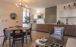 a kitchen and living room with a table and a dining room at Alkimya Stylish Haven by LAHOS in Mérida