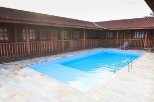 a large blue swimming pool next to a house at Hotel Pousada Gavi e Nono in Santa Ernestina